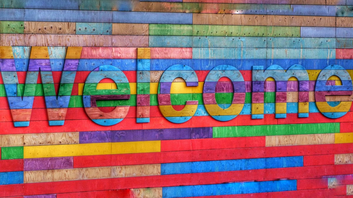 A multi-color wooden sign saying "Welcome"