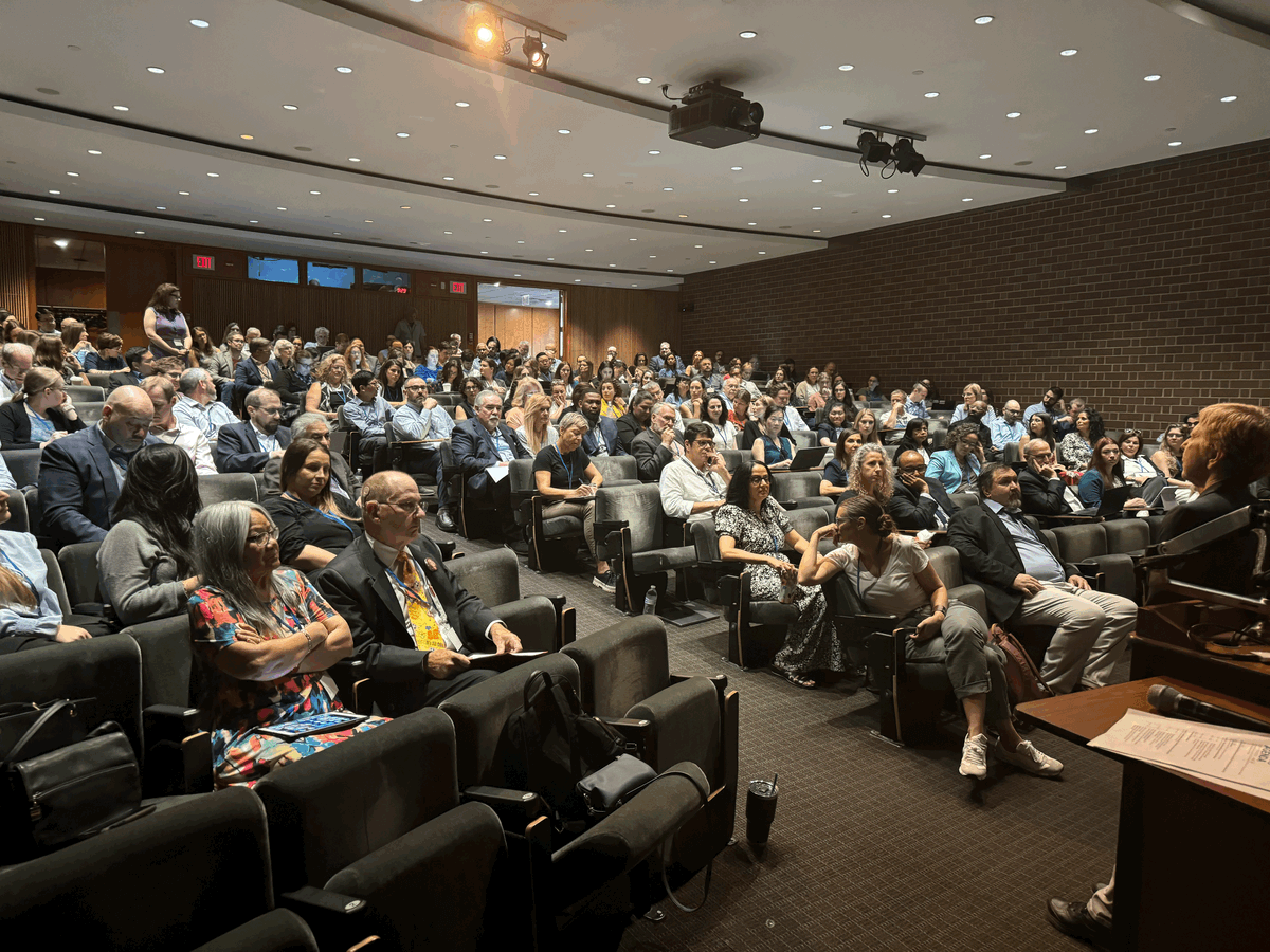 A lecture hall with attendees and a speaker at ClinPGx 2024